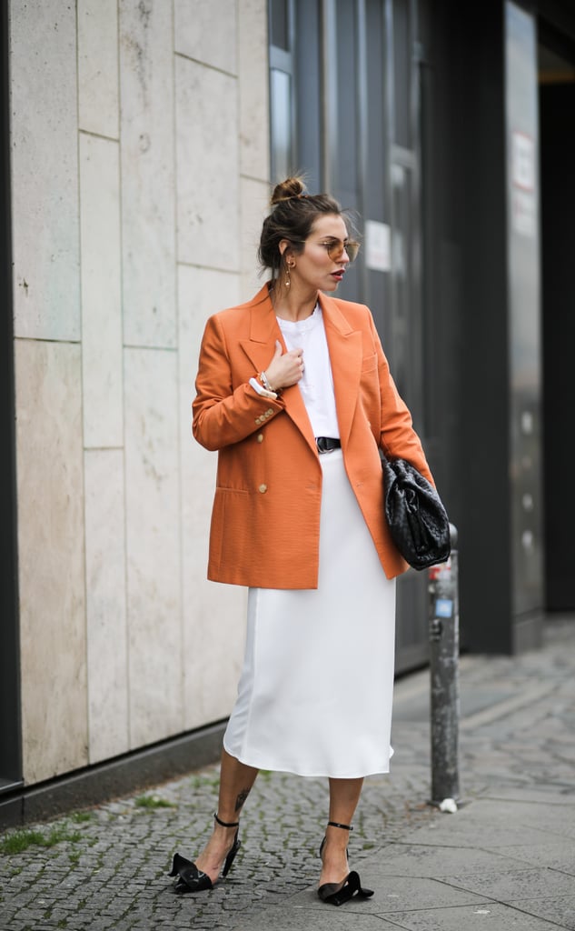 A boldly-coloured blazer is effortlessly chic for work with a white t-shirt, midi skirt, and pumps.