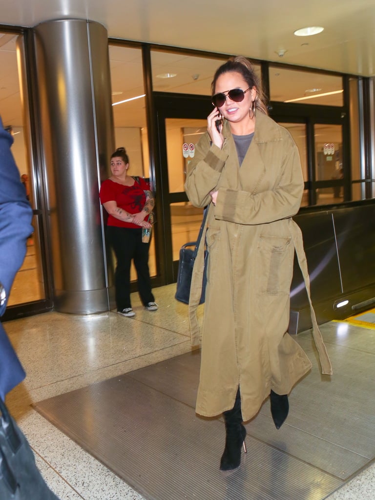 Chrissy was seen at LAX wearing a camel-hued trench coat, gray shirt, and suede boots. She finished her look off with hoops by Svelte Metals.