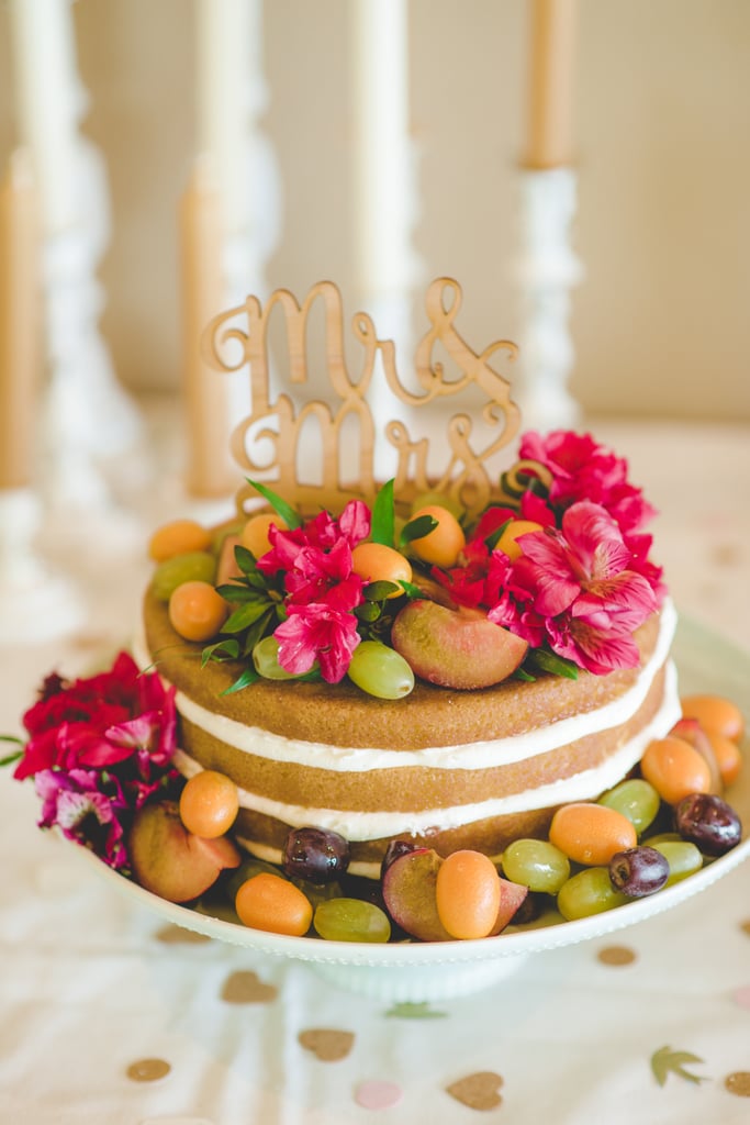 Azaleas, kumquats, and grapes are scattered among this naked layer cake.