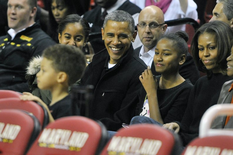 COLLEGE PARK, MD - NOVEMBER 17: President of the United States Barack Obama with his daughters Malia (L) and Sasha (R) and wife Michelle in their seats before a college basketball game between the Oregon State Beavers and the Maryland Terrapins at the Com