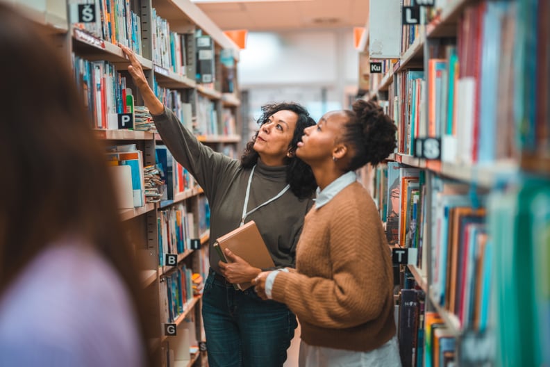 A library card holder asks a librarian for help finding a title at her local branch, where her library card benefits get her lots of free things.
