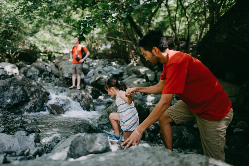 Japanese father and his mixed race little girl hiking in river, Japan