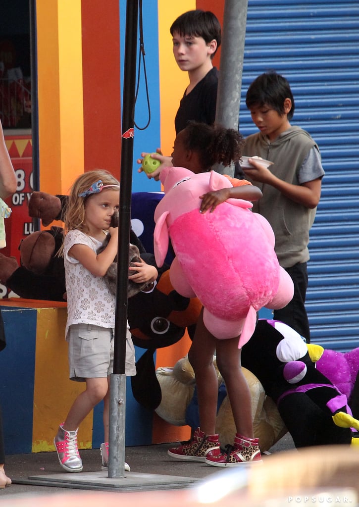 Pax snacked on a sweet while Zahara collected a large stuffed animal at a canival game.