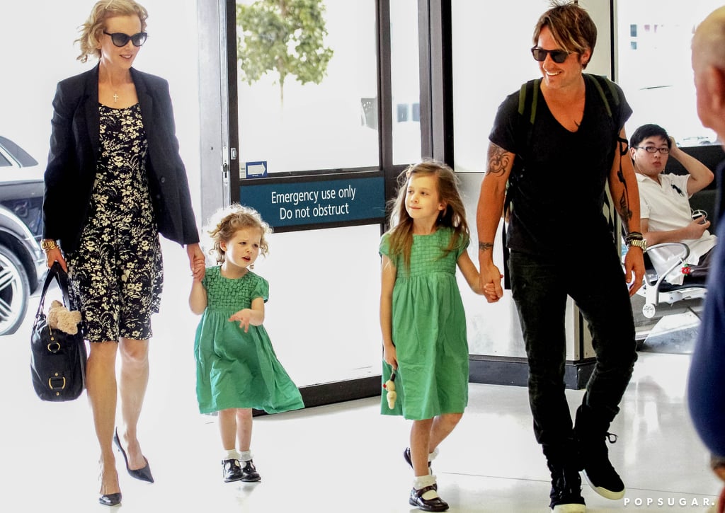 Keith and Nicole smiled while holding their kids' hands.