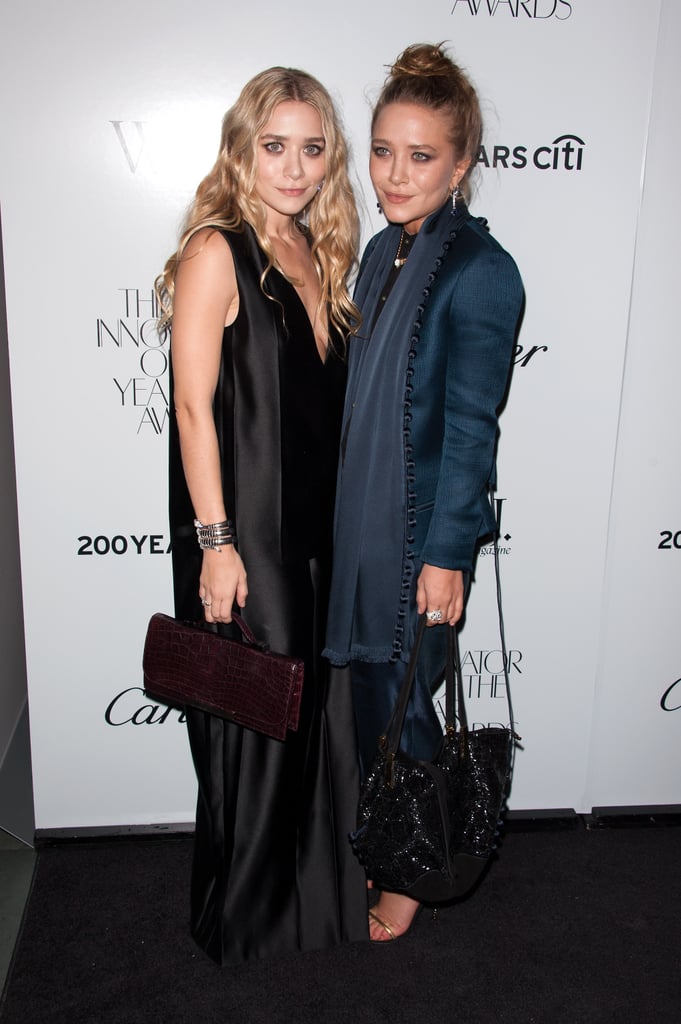 Twinning combo: In October 2012, the Olsen sisters hit the WSJ Magazine's Innovator of the Year Awards in moody hues, both by The Row.

Ashley worked a silky black V-neck dress with pleated panels, while toting all her party essentials in a burgundy bag by The Row.
Mary-Kate beat the Winter blues in a sleek navy suit of tapered pants and a tailored blazer featuring a soft waterfall detail.