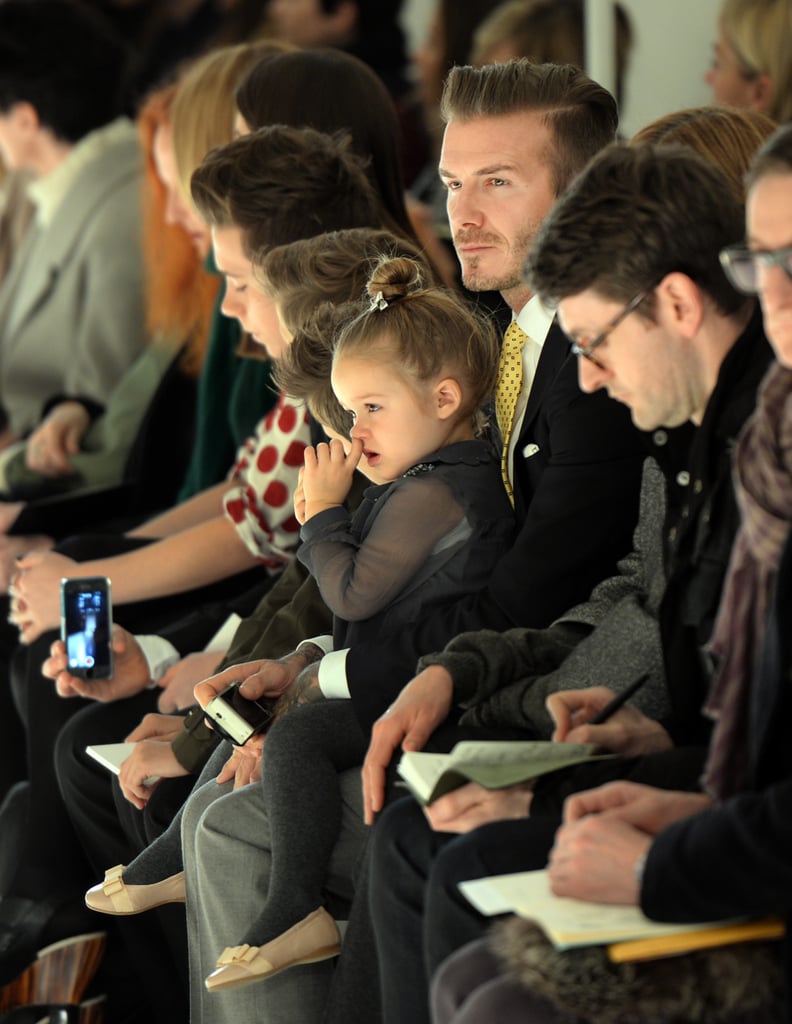 David Beckham held his daughter, Harper, on his lap as they watched Victoria's show at New York Fashion Week on Sunday.