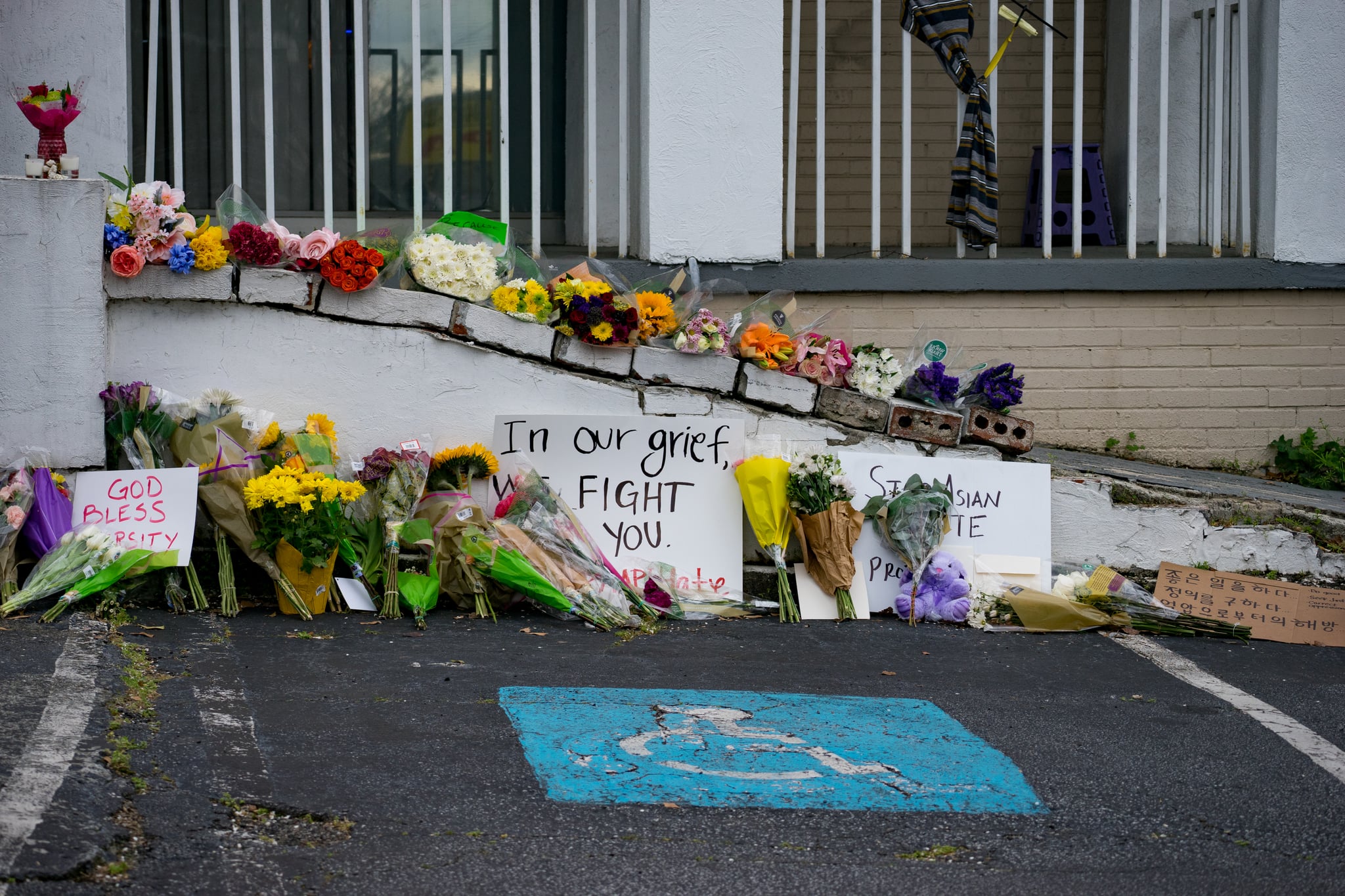 ATLANTA, GA - MARCH 18: Flowers and signs adorn Gold Spa during a demonstration against violence against women and Asians following Tuesday night's shooting where three women were gunned down on March 18, 2021 in Atlanta, Georgia. Suspect Robert Aaron Long, 21, was arrested after a series of shootings at three Atlanta-area spas left eight people dead, including six Asian women. (Photo by Megan Varner/Getty Images)