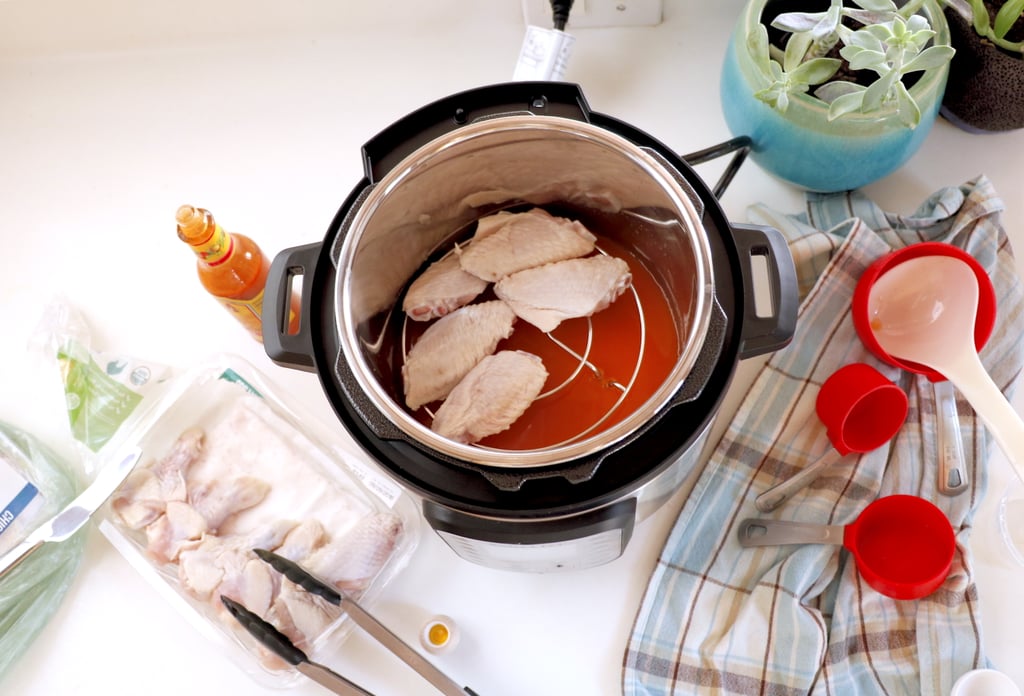 Pour 3/4 cup water and 1/4 cup hot sauce into the bottom of the Instant Pot. Stir. Add the trivet (this comes with most Instant Pots or can be bought online), and place the chicken on top.
