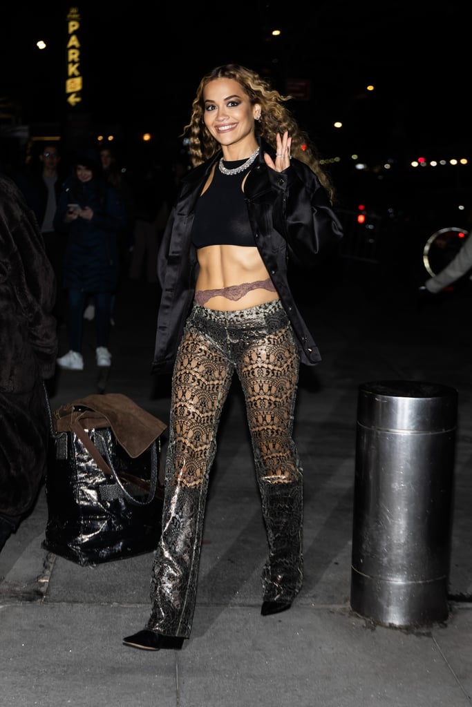 Rita Ora has been booked and busy promoting her new single "You Only Love Me" in New York City. On Feb. 1 alone, she was photographed in seven different outfits for numerous appearances. Among her many ensembles, Ora wore a particularly bold look featuring a halter bra top, entirely sheer lace pants, and what can only be described as a strip of lace cut across her abs. Collaborating with her stylist Tom Eerebout, the recently married singer-songwriter styled the polarizing pieces with an oversize black jacket, knee-high boots, and an assortment of diamond jewelry.
That same day, Ora also wore a silver sequin top and matching miniskirt from David Koma, before changing into pink Versace lingerie for "The Tonight Show Starring Jimmy Fallon," where she revealed her massive emerald engagement ring and delicate diamond wedding band for the first time. She managed to squeeze in an appearance at a concert for the American Heart Association as well, wearing a long-sleeve bodycon dress and a see-through cutout dress, both in bright red. 
"The Masked Singer" judge is unafraid of a controversial trend — or freezing-cold temperatures, for that matter. During another press day on Jan. 31, she paired a knit Miu Miu minidress with knee-high thong sandals by the designer, which were a cross between a boot and a sandal. While performing "You Only Love Me" live for the first time in London on Jan. 28, she embraced the sheer look once again in a latex dress with star-shaped nipple pasties.
See more photos of Ora's latest street style outfit ahead.

    Related:

            
            
                                    
                            

            Rita Ora Debuts a New Side-Boob Tattoo