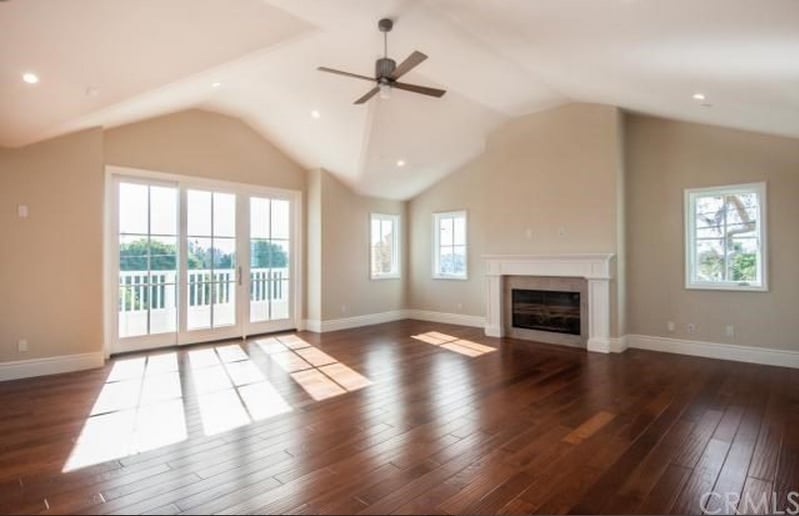 Another angle of the living room, which has a fireplace and high ceiling.