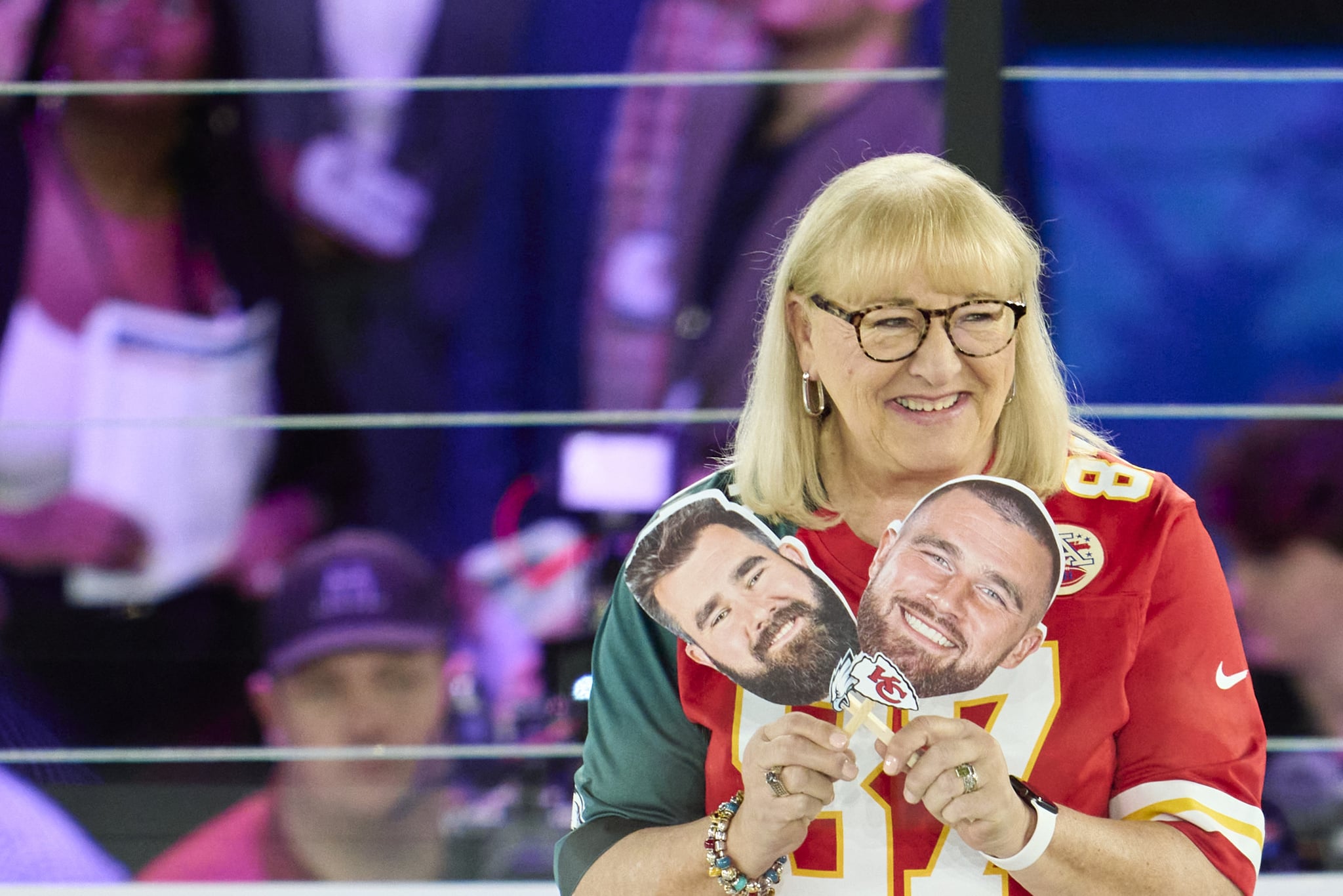 Donna Kelce holds up photos of her sons, Jason Kelce #62 of the Philadelphia Eagles and Travis Kelce #87 of the Kansas City Chiefs at Footprint Center on February 6, 2023 in Phoenix, Arizona