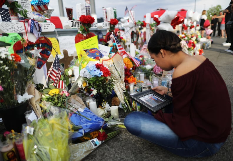 EL PASO, TEXAS - AUGUST 06: Yamileth Lopez holds a photo of her deceased friend Javier Amir Rodriguez at a makeshift memorial for victims outside Walmart, near the scene of a mass shooting which left at least 22 people dead, on August 6, 2019 in El Paso, 