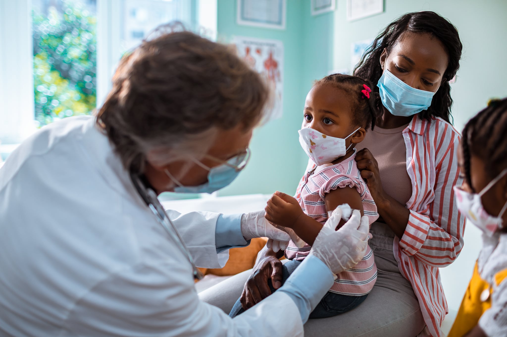 Close up of a mother taking her daughter to the pediatrician to get vaccinated