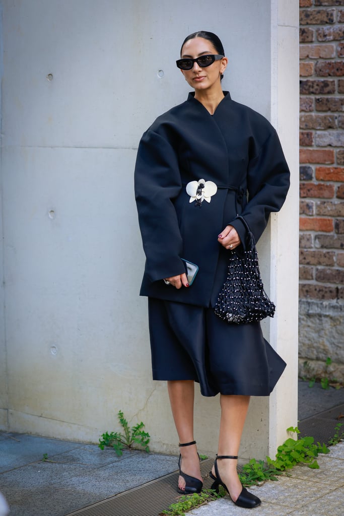 A guest added visual interest to her navy and black outfit with a white brooch.