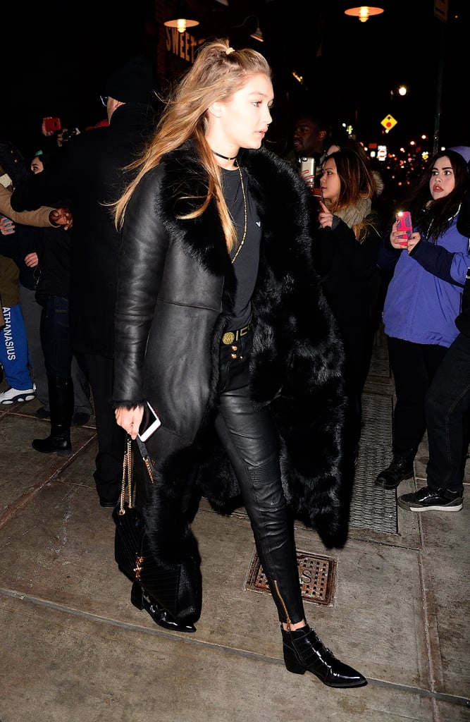 This all-black look is so "rock star" to us. Leather pants, furry coat, gold details — it's like she's headed to a show!