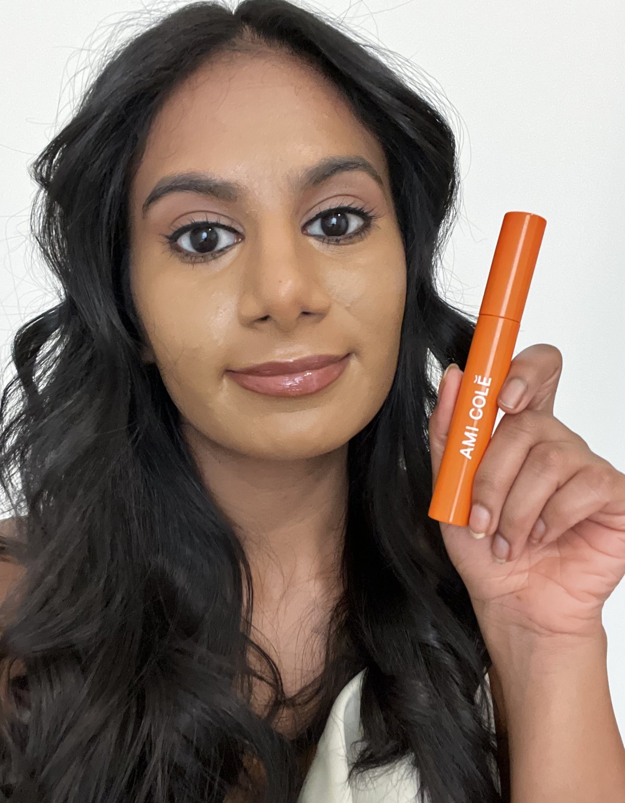 Woman holding the Ami Cole Lash Amplifying Mascara.