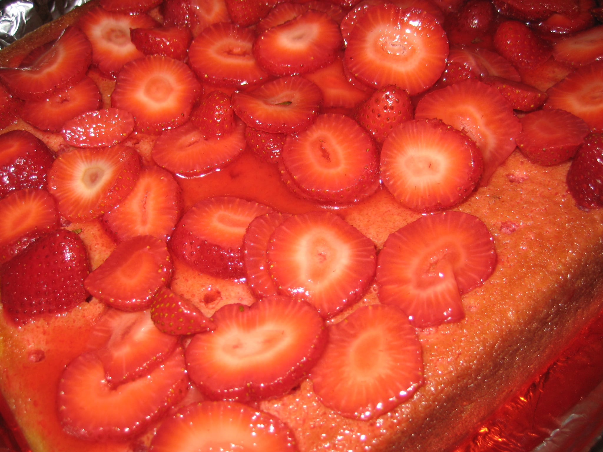 Evenly spread the strawberries over the cake. 