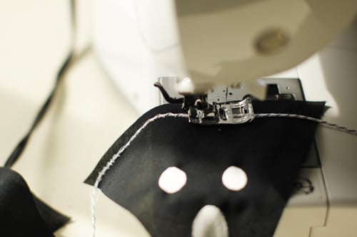 After the little spooky faces dried completely I sewed each one of them to my baker's twine to create a banner. The stitch I used was a zig-zag over the top of the twine to make sure the twine was secured all the way down one side of the triangle.