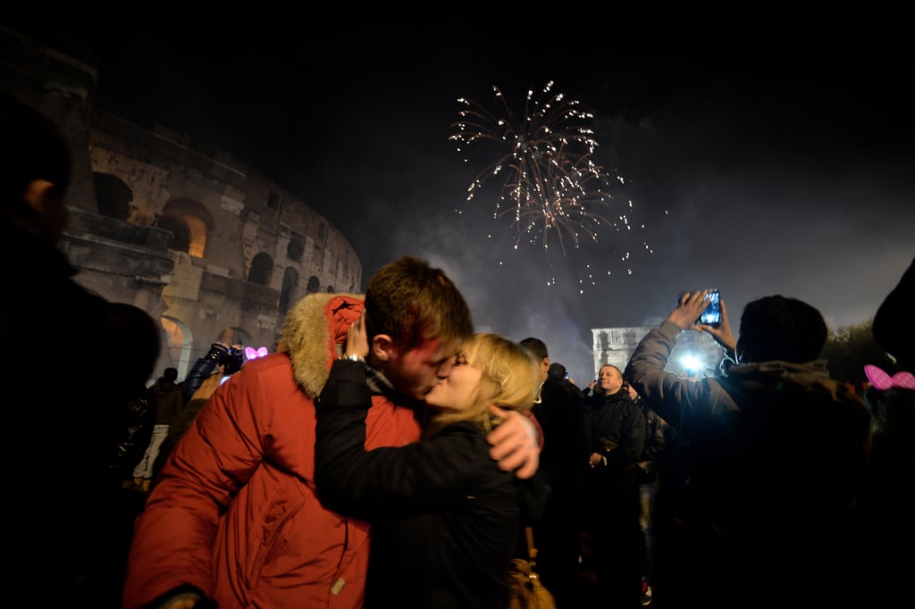 A couple kissed outside of the Colosseum in Rome, Italy.