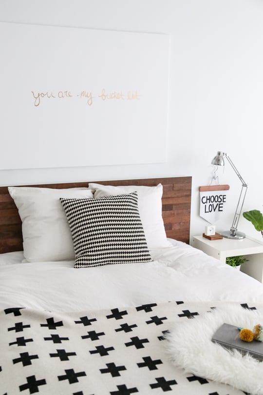 A simple Ikea headboard is elevated with the application of wood planks.