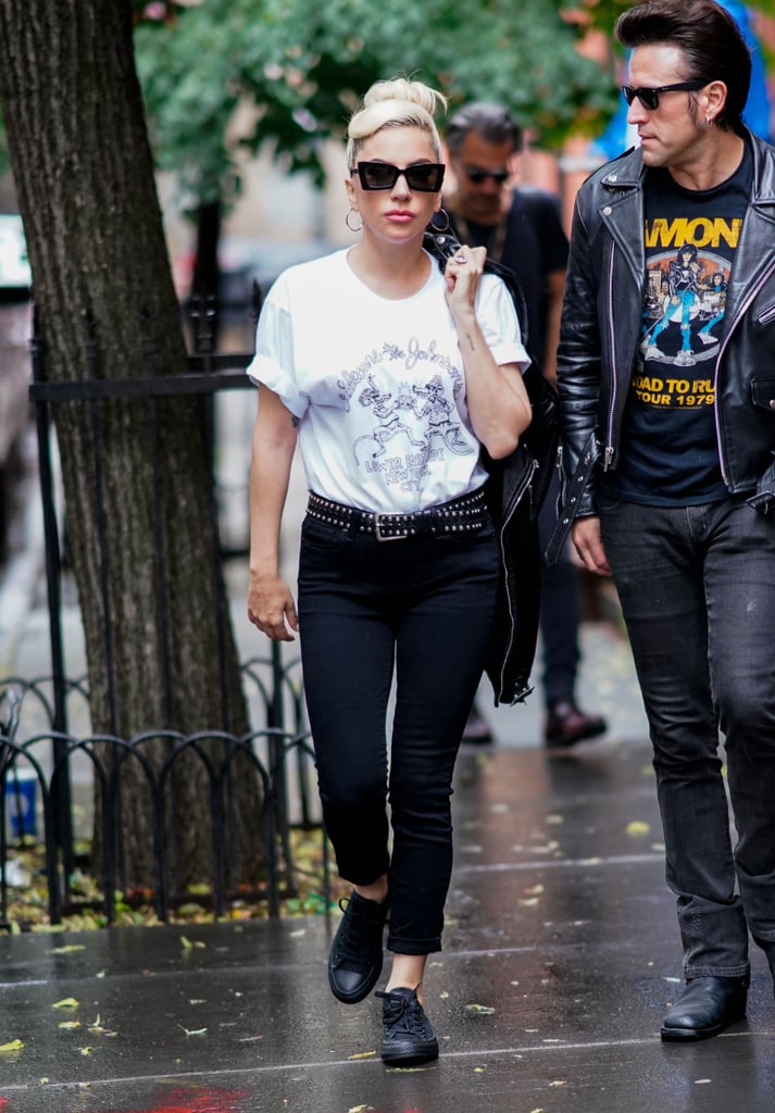 Wearing Paige jeans, a Saint Laurent tee, Converse sneakers, and Karen Walker sunglasses.