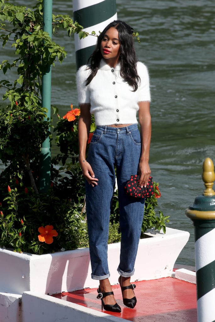 Wearing a fuzzy white top, cuffed jeans, and velvet mules, all from Miu Miu.