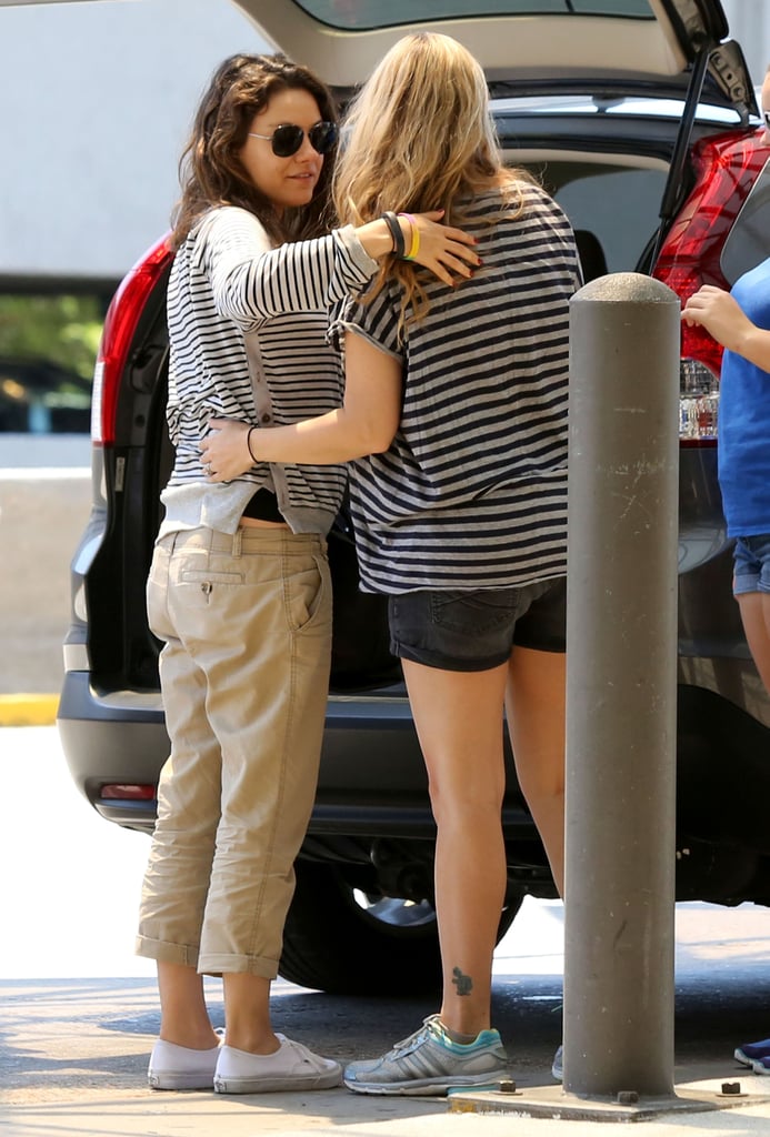 Mila Kunis Shows Baby Bump at Airport With Ashton Kutcher