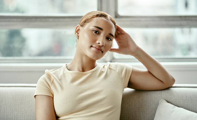 Woman Sitting on Couch Resting Her Head on Her Hand