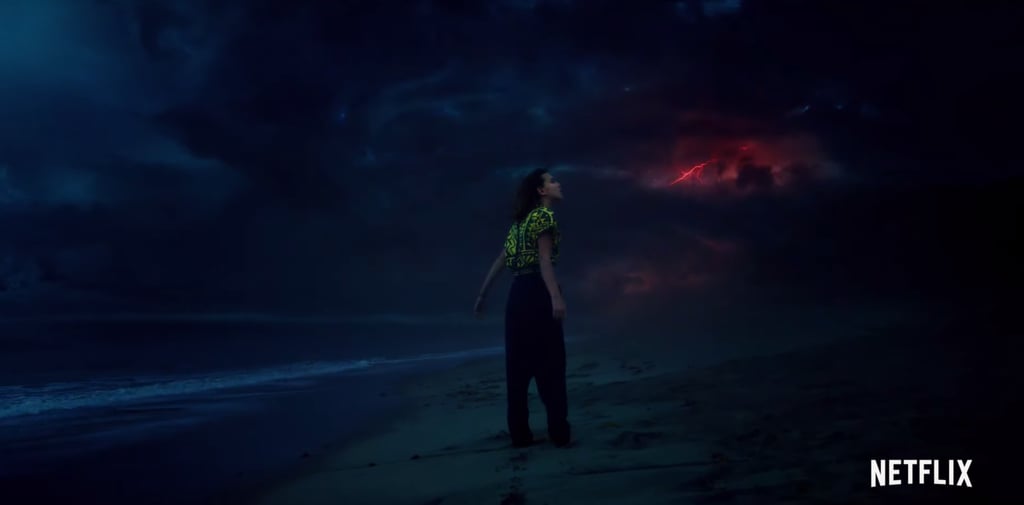 Eleven winds up on a beach somewhere, with a storm brewing in the distance. What's important to note about this shot, though, is that she doesn't seem to be in the real world; that red lightning burst in the distance is a trademark of the Upside Down. We also know, based on some set pictures, that she'll be exasperated and rolling around in the ocean at some point, so that does not bode well.