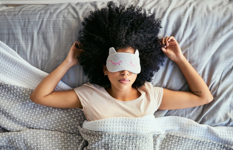 Shot of a young woman sleeping with a mask on in bed