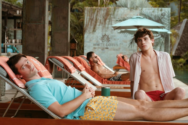 Saxon and Lochlan Ratliff in an episode of The White Lotus relaxing on beach chairs by the pool.
