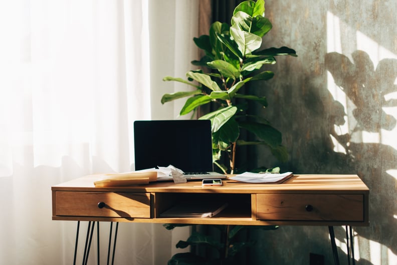 a desk with paperwork and an open laptop