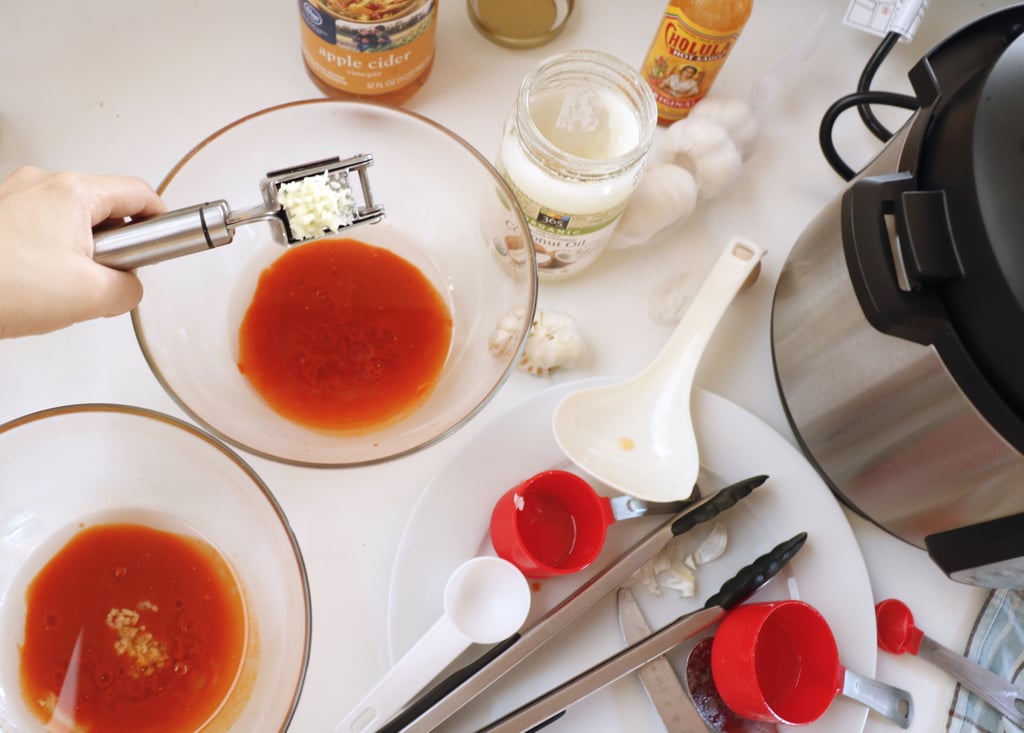 Melt half a cup of coconut oil in the microwave for 30 seconds, and then divide it evenly in two medium-size bowls. Then add into each one:

1/4 cup plain hot sauce (Cholula's, Frank's, Tabasco, or brand of your choice)
1/2 tablespoon apple cider vinegar
1 small garlic clove, crushed
1/4 teaspoon salt

Whisk together with a fork. 
This is a modified version of a Whole30 recipe — and I think you can't tell the difference from regular buffalo sauce, even though it's much healthier. If you prefer to use a more classic version, or a store-bought one, just place 1/2 cup of the sauce in each bowl.