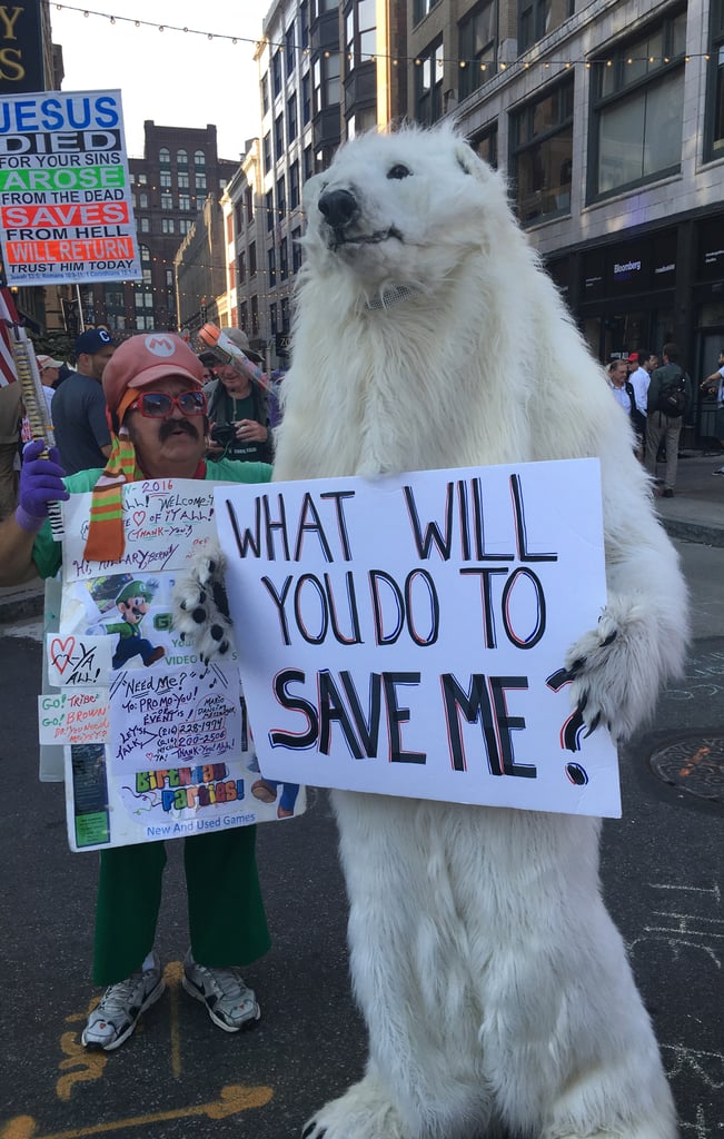 A polar bear with a message about extinction stood next to a costumed Mario promoting his entertainment services.