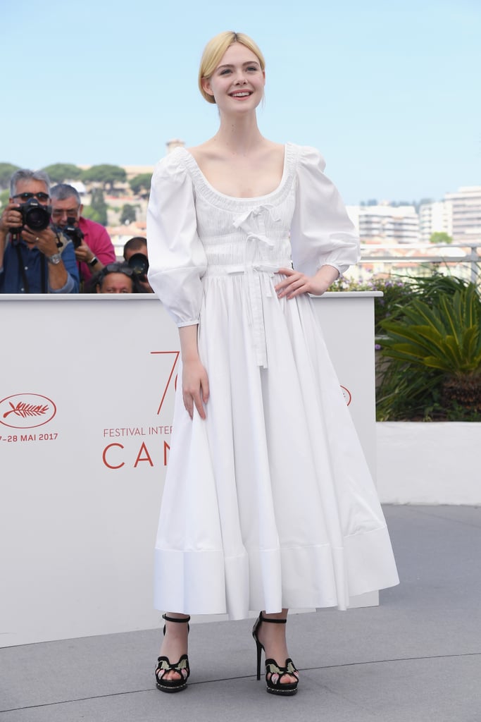 "Elle pulled out her Alexander McQueen prairie dress for The Beguiled photo call, and she grounded the cloud-like number with a pair of embellished platform sandals. The look felt breezy and natural, especially since the star swept up her hair to put her midi's details on display — bishop sleeves, ruched bodice with bows, and all." — SW