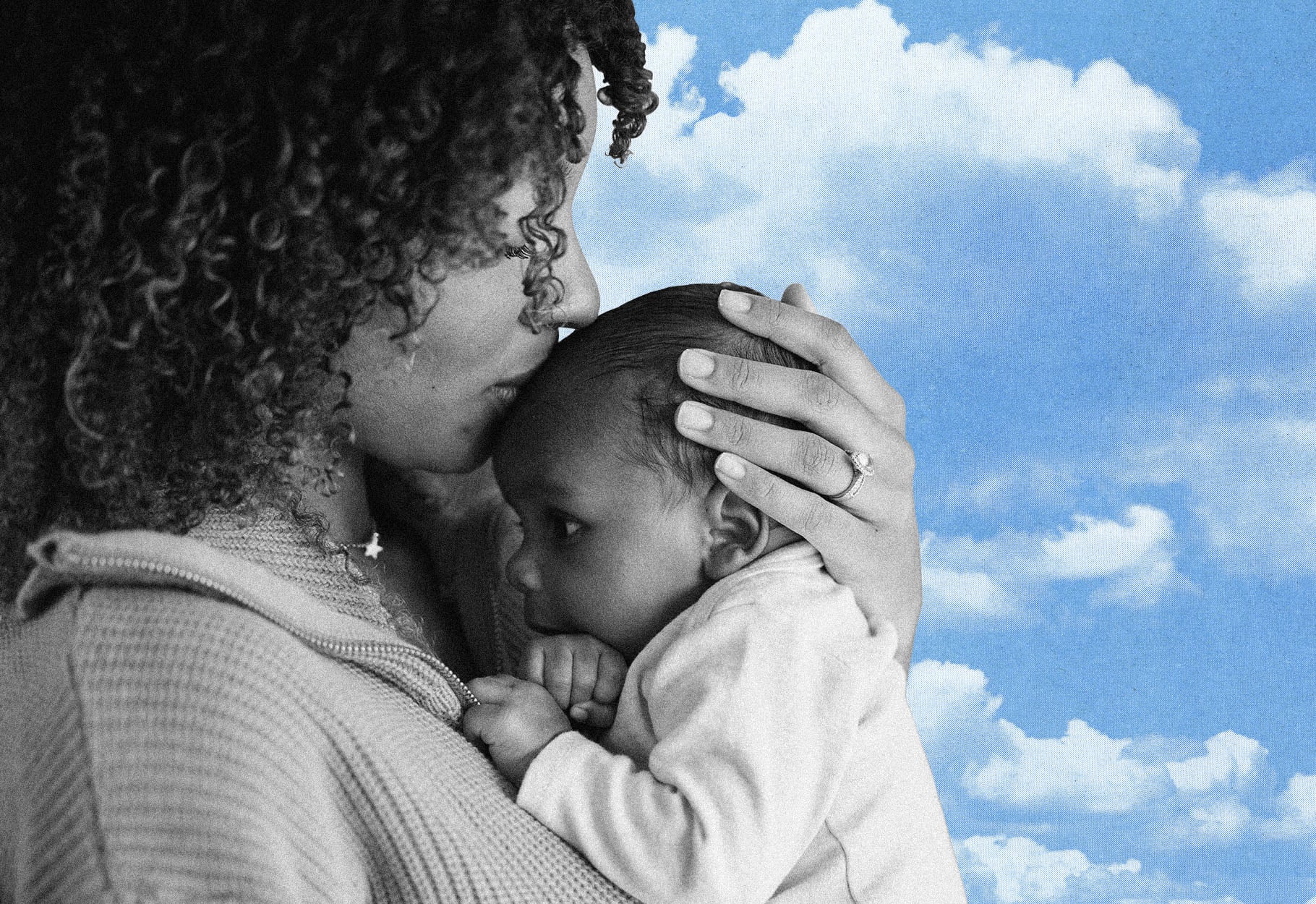 Woman Kissing Her Baby's Forehead on a Blue Sky and Clouds Background