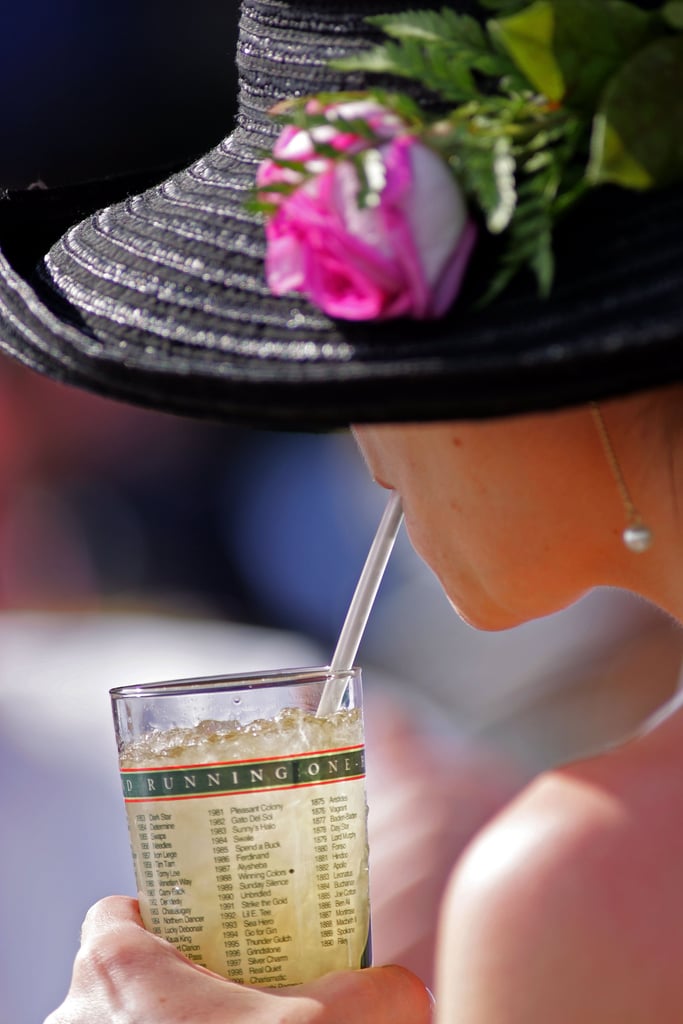 A fan drank a mint julep under her pink and black hat in 2006.