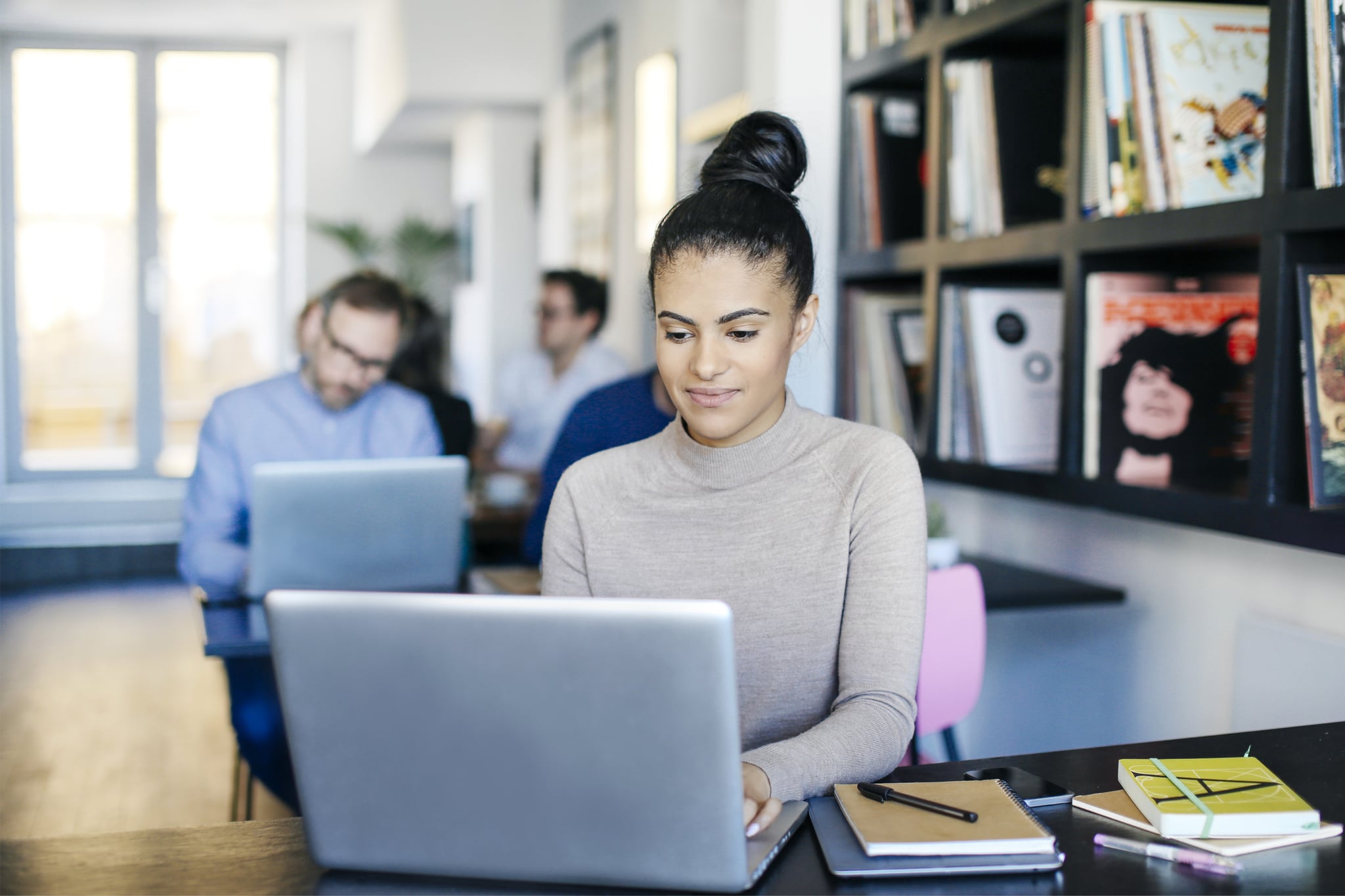 Young woman working on laptop computer in a London cafe.