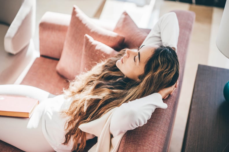 Woman relaxing on sofa in living room during the follicular phase.