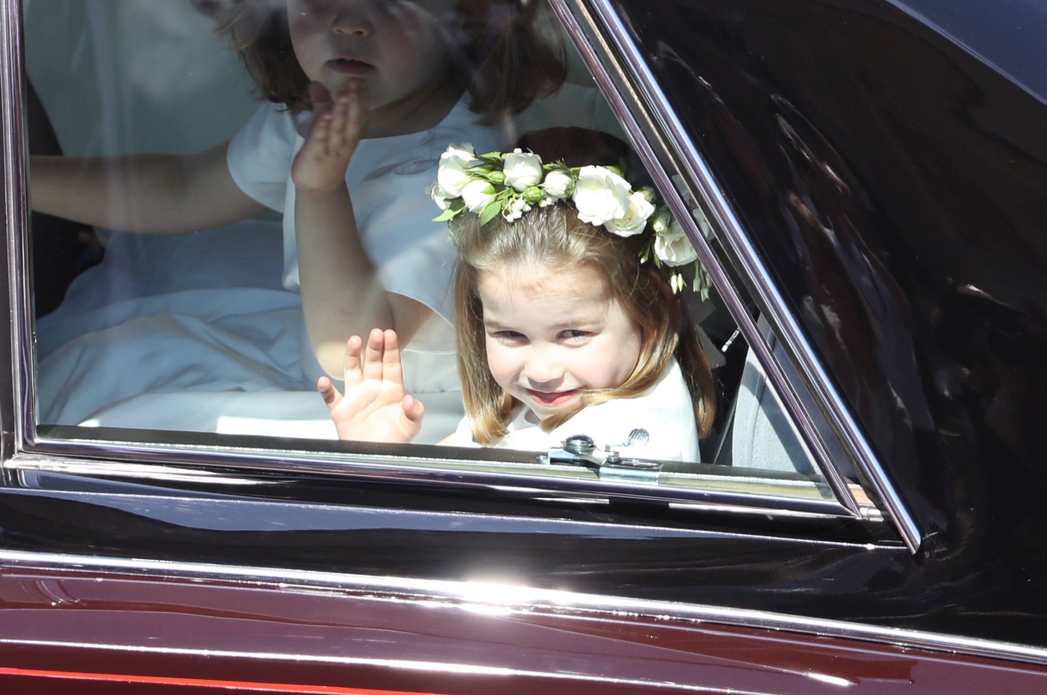 WINDSOR, ENGLAND - MAY 19:  Princess Charlotte waves to the crowd as she rides in a car to the wedding of Prince Harry and Meghan Markle at St George's Chapel in Windsor Castle on May 19, 2018 in Windsor, England.  (Photo by Andrew Milligan - WPA/Getty Images)