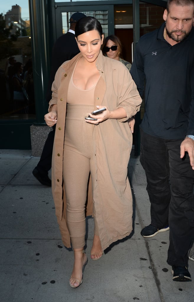 Sticking to the signature color palette, Kim paired a tight tan jumpsuit with a duster of the same color for Kanye's fashion show.