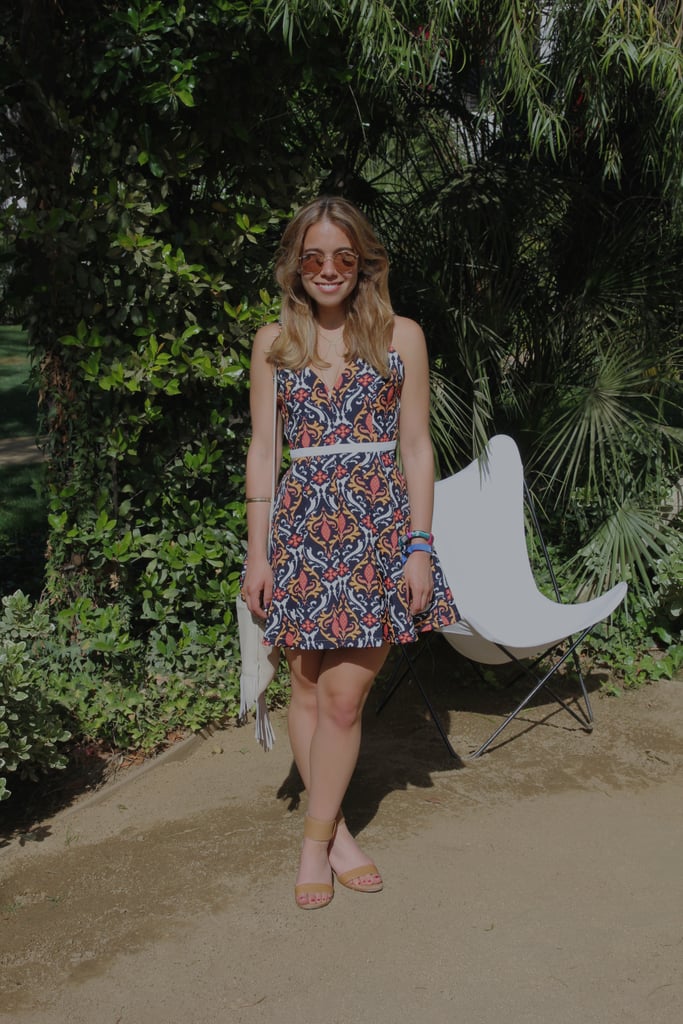 Popsugar Fashion Editorial Assistant Sarah Wasilak accessorized a playfully printed babydoll dress with a cream fringe bag, neutral Dolce Vita sandals, and mirrored Ray-Ban sunglasses.