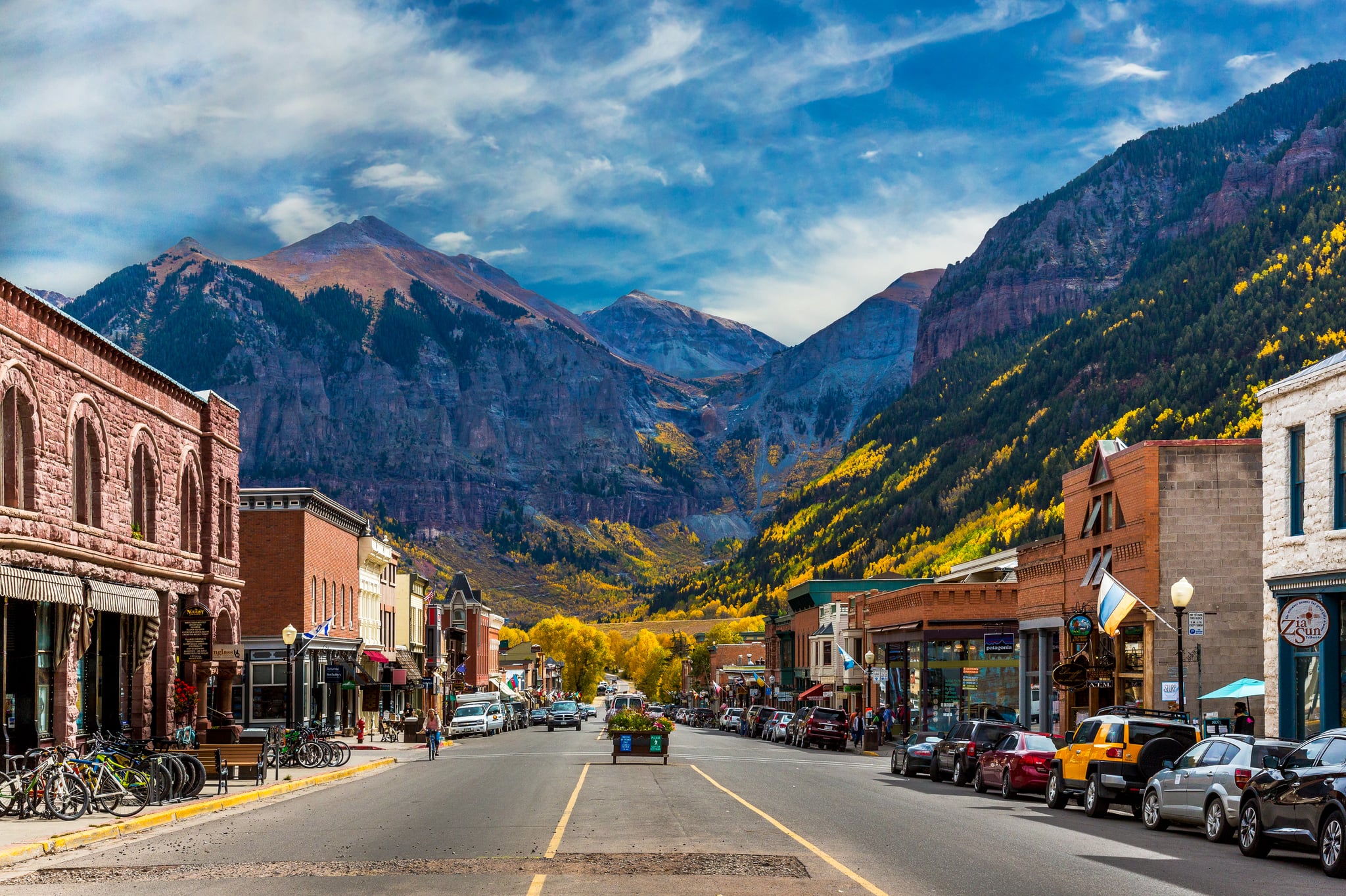 A look down Main Street in Telluride, CO., with peak gold autumn color from the Aspen trees blanketing the Rocky Mountain backdrop.