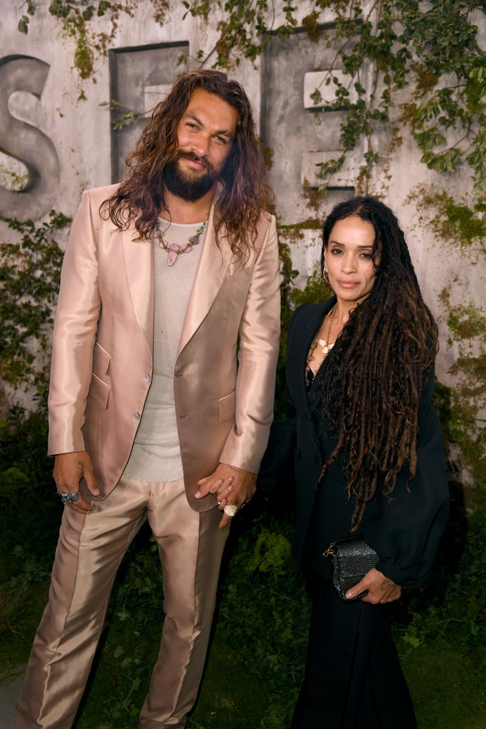 Jason Momoa and Lisa Bonet made a date night out of the actor's recent premiere for Apple TV+'s new series, See. The longtime couple showed subtle but sweet PDA as they walked the red carpet hand-in-hand. While Jason looked dapper in a light pink suit, we're especially obsessed with Lisa's sleek and understated look. Even Jason couldn't hide his big smile as he leaned into his wife while they posed for photos. 
The cute appearance comes a week after Jason opened up about marrying his childhood crush to Esquire. After growing up fawning over Lisa, the actor talked about how his dreams came true when a mutual friend introduced them in 2005. Flash forward to today, and the couple is married and have two kids, Lola and Nakoa-Wolf, along with Zoë Kravitz, whom Lisa shares with Lenny Kravitz. "If someone says something isn't possible, I'm like, 'Listen here, I married Lisa Bonet. Anything is possible,'" he told the publication.