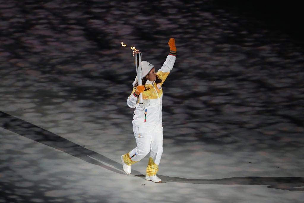 A torchbearer enters the stadium.