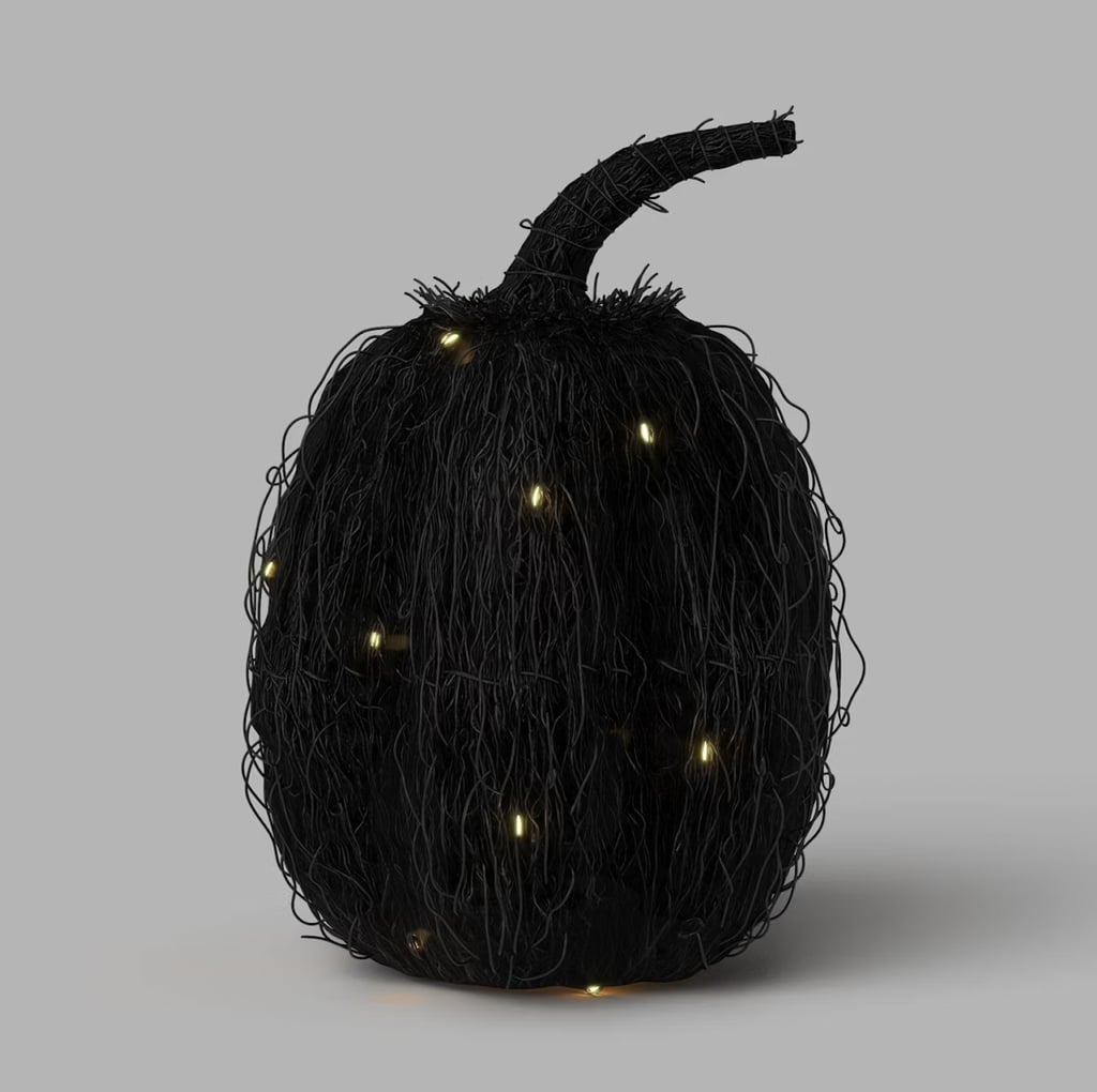 Threshold 11" Woven Rattan Lit Halloween Pumpkin ($25)
Although a smiling jack-o'-lantern is uplifting, this woven alternative will add a gothic, moody vibe to your space. The black rattan pumpkin will look great on a coffee table, shelf, or on top of the mantel. It even has just a few hidden lights to add to the spook factor.