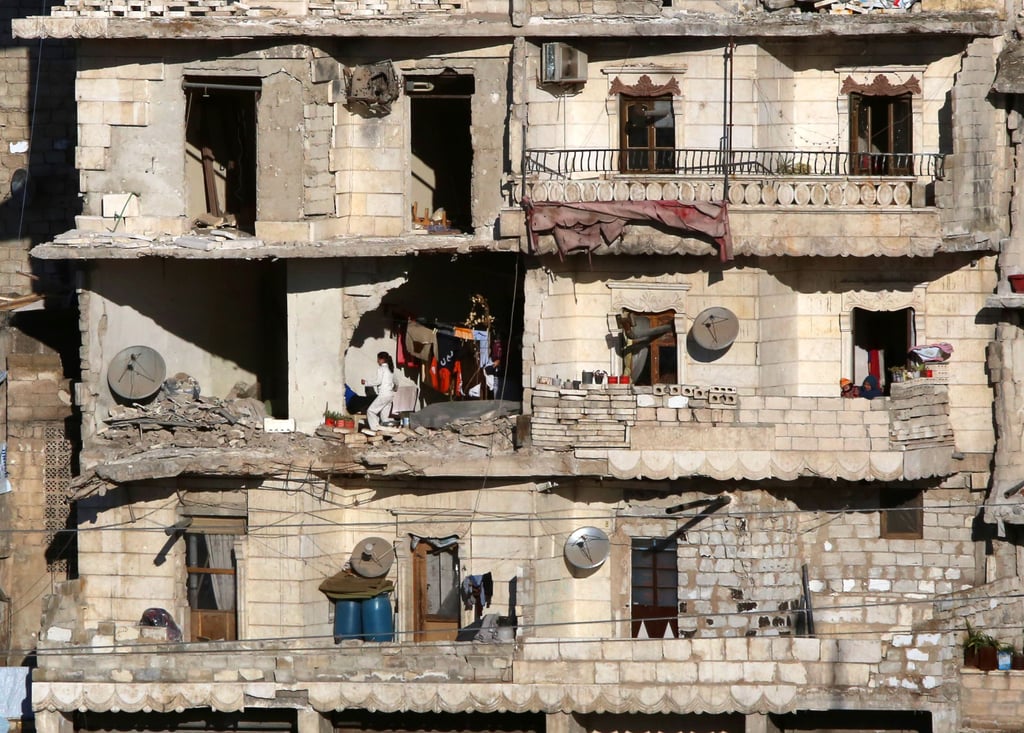 Aleppo residents watch as buses evacuate rebels and their families on Dec. 15.