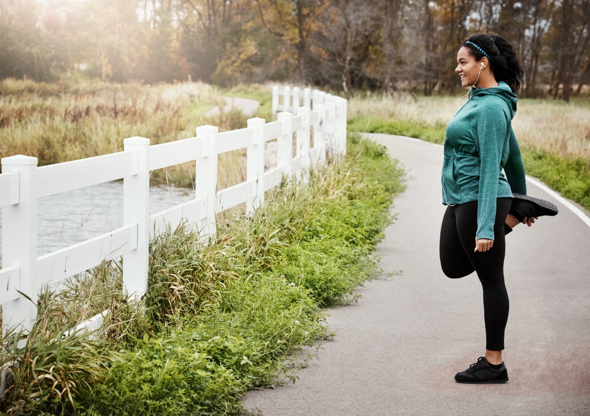 Shot of an attractive young woman stretching while out for a run in nature