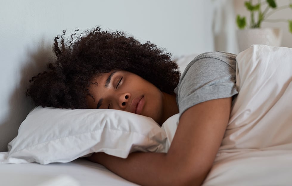 Woman sleeping in bed with her head on a pillow