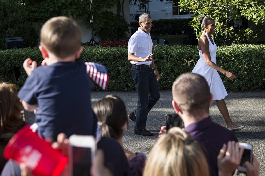 Onlookers waved their American flags as the president and first lady greeted people at the White House in 2014.